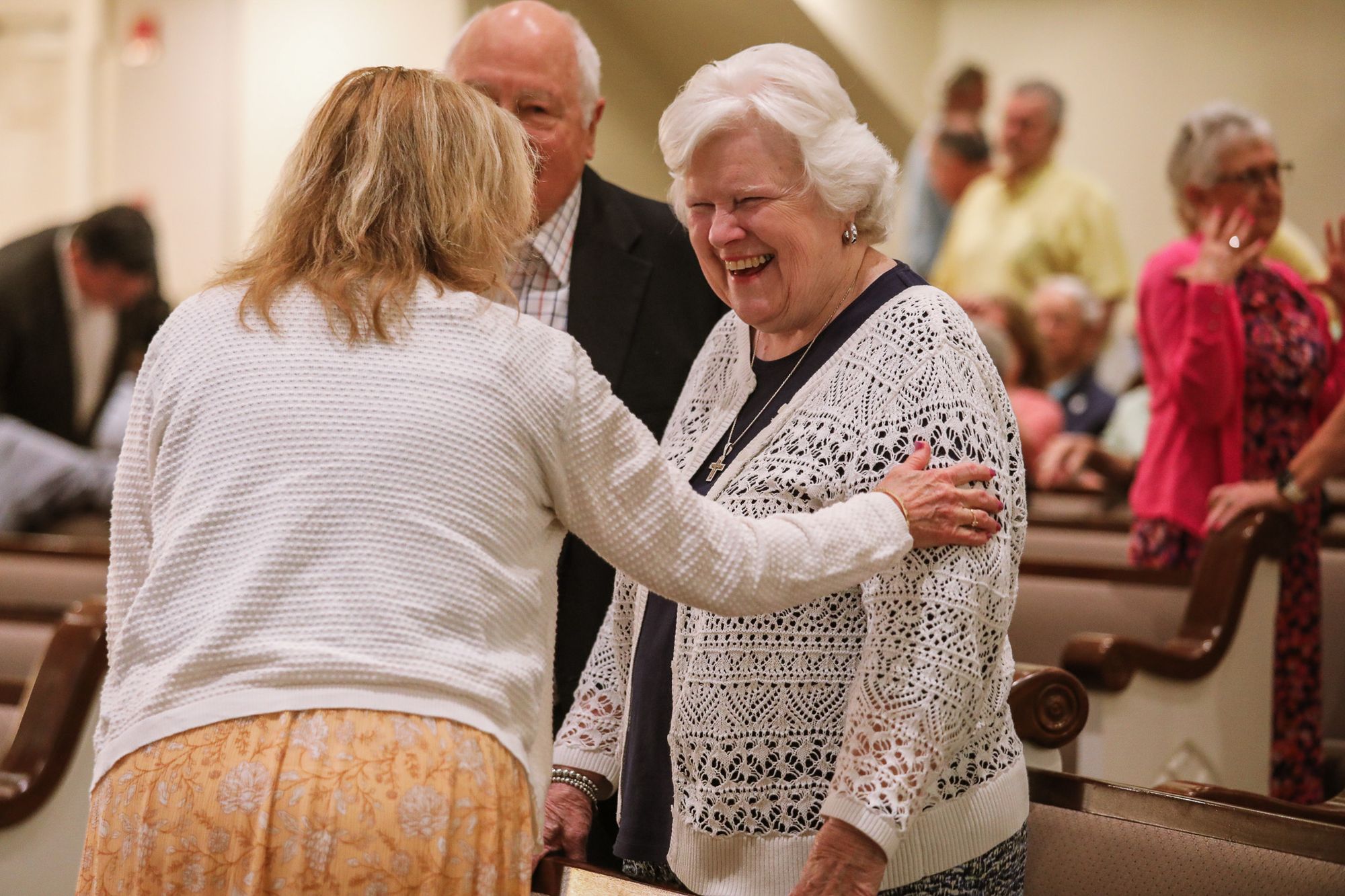 Church members greeting each other with a hug during a Sunday service